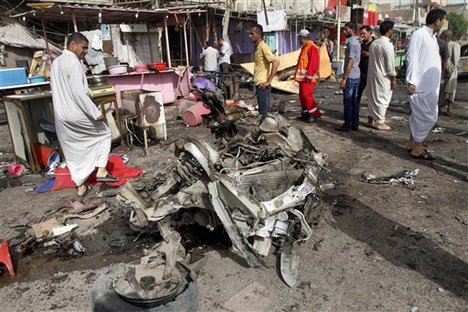 Civilians gather at the site of a car bomb attack in front of a crowded popular restaurant in Basra, 340 miles (550 kilometers) southeast of Baghdad, Iraq, Monday, May 20, 2013.