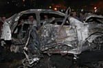 This photo released by the Syrian official news agency SANA, claims to show Syrians inspecting a damaged car at the scene of a car bomb which exploded, in Damascus, Syria, Saturday, May 18, 2013.