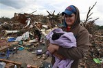 Austin Brock holds cat Tutti, shortly after the animal was retrieved from the rubble of Brock's home, which was demolished a day earlier when a tornado moved through Moore, Okla., Tuesday, May 21, 2013