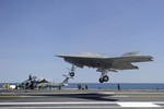 An X-47B Unmanned Combat Air System (UCAS) demonstrator conducts a touch and go landing on the flight deck of the aircraft carrier USS George H.W. Bush (CVN 77), marking the first time any unmanned aircraft has completed a touch and go landing at sea, 17 May, 2013.