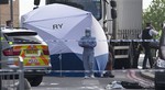 Police and forensic officers near the scene of an attack which has left one man confirmed dead and two people injured near Woolwich barracks in London Wednesday, May, 22, 2013.