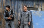 Afghan police take cover following a suicide attack in Kabul, Afghanistan, Friday, May 24, 2013.