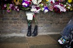 Military boots are laid in tribute outside the Woolwich Barracks, in London, Friday, May 24, 2013, in response to the bloody attack on Wednesday when a British soldier was killed in the nearby street.