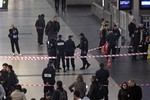 Police officers stand near the cordoned off spot where a French soldier was stabbed in the throat in the busy commercial district of La Defense, outside Paris, Saturday May 25, 2013, and France's president said authorities are investigating any possible links with the recent slaying of a British soldier.