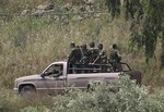 Syrian army soldiers stand in their vehicle as they reinforce the village of Arida near Talkalakh opposite the Lebanon-Syria border, in Wadi Khaled, north Lebanon, on Thursday May 19, 2011.