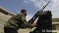 A Free Syrian Army fighter takes position by pointing an artillery weapon towards the sky . REUTERS/Abdalghne Karoof