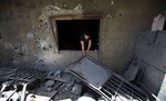 A Lebanese man removes debris from his damaged house, hit by rockets fired by Syrian rebels according to villagers, in Hermel town, northeast of Lebanon, Wednesday May 29, 2013.