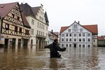 Rudolf (11) crosses the flooded market place of the city of Wehlen at river Elbe, Germany, Tuesday, June 4, 2013. After heavy rainfalls, swollen rivers flooded areas in Germany, Austria , Switzerland and Czech Republic.