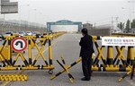 A South Korean owner who runs a factory in the stalled South Korea and North Korea's joint Kaesong Industrial Complex, stands just outside of military barricades set up on Unification Bridge near the border village of Panmunjom, which has separated the two Koreas since the Korean War, in Paju, north of Seoul, South Korea, Thursday, May 30, 2013.