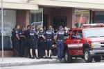 Los Angeles police officers gather in the city's westside Palms district where they investigated a home that was believed to be connected in some way with shootings in nearby Santa Monica,. Calif., Friday, June 7, 2013.