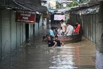 Indian people use a boat to cross a Tibetan market along the banks of the Yamuna River, in New Delhi, India, Wednesday, June 19, 2013. With heavy rainfall in northern India several cusec of water have been released from barrages upstream flooding the banks of the Yamuna along Delhi.