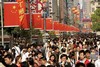 People walk at a shopping street Tuesday, May 1, 2007 in Shanghai, China. May Day, on May 1, is traditionally the day socialist countries honor their workers, but in modern communist China the day kicks off a week-long Golden Week holiday which the government hopes will encourage its citizens to travel and spend, thereby boosting the economy. 