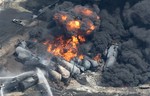 Smoke rises from railway cars that were carrying crude oil after derailing in downtown Lac Megantic, Que., Saturday, July 6, 2013.