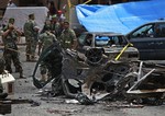 Security forces stand at the scene of a bombing in the Beir el-Abed, a southern suburb of Beirut, Lebanon, Tuesday, July 9, 2013.