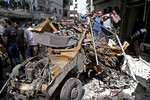 In this photo released by the Syrian official news agency SANA, Syrians investigate damages after two suicide bombings hit security compounds in Damascus, Syria, Wednesday, June 23, 2013.