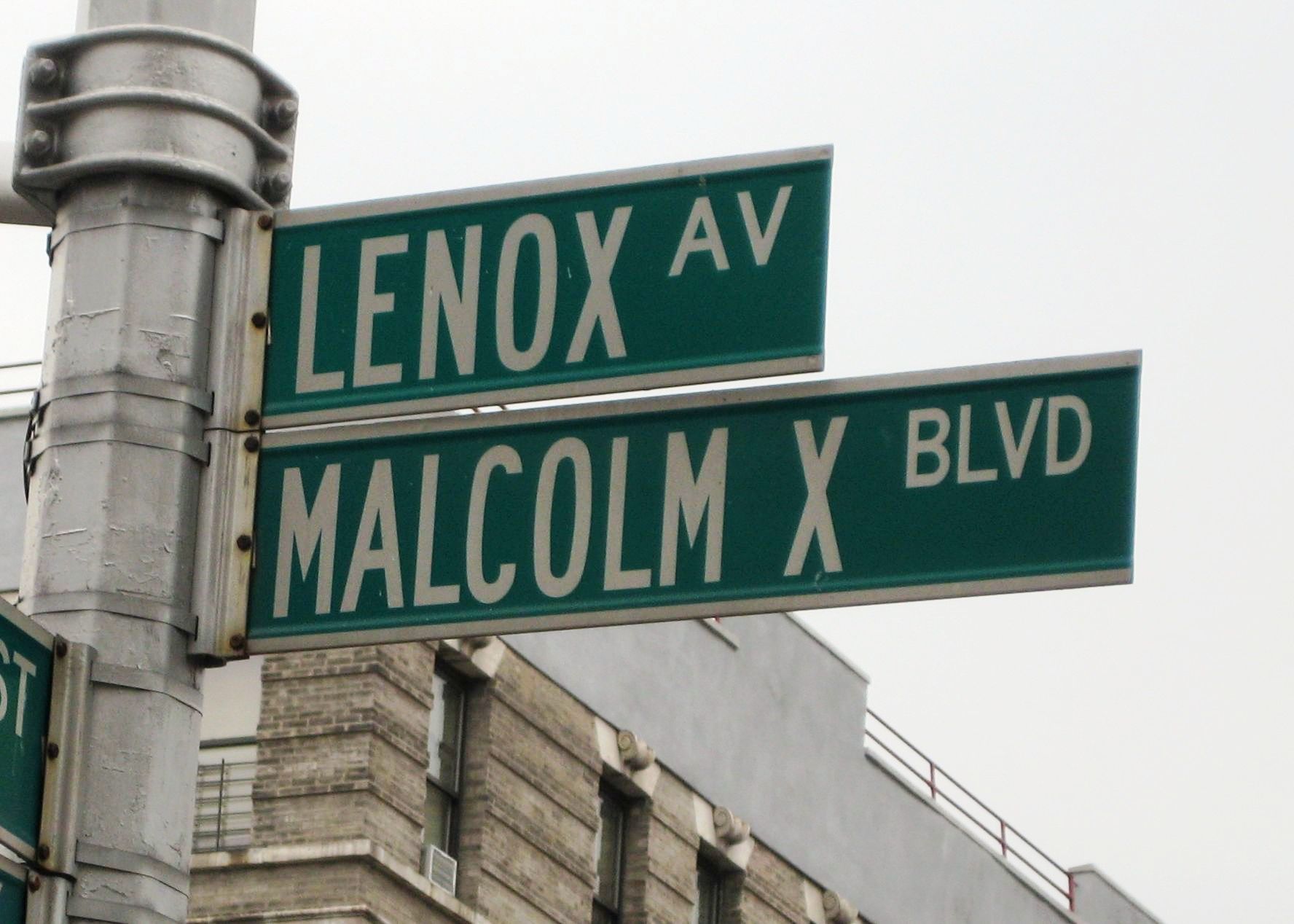 Two green street signs, one reading Lenox Avenue, the other reading Malcolm X Boulevard