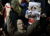 An opponent of ousted President Mohammed Morsi holds up a poster of Egyptian Defense Minister General Abdul Fatah al-Sisi with an Arabic words that read:"Greeting for al-Sisi, a man wrote his name in the historic of the greatest," during a rally at Tahrir square, in Cairo, Egypt, late Friday, July 19, 2013.