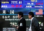 Passers-by are seen in front of an electronic stock board in downtown Tokyo, Japan, Friday, Nov. 21, 2008.