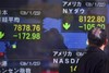 A man looks at the electronic stock board of a securities firm in Tokyo, Japan, Friday, Jan. 23, 2009. Japan's Nikkei Average fell 2.8 percent from Thursday during morning tr