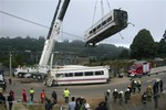 Derailed cars are removed as emergency personnel work at the site of a train accident in Santiago de Compostela, Spain, on Thursday, July 25, 2013.