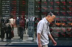 A man walks by a stock board outside a securities' firm in downtown Tokyo Monday, Aug. 6, 2007. The 225-issue Nikkei Stock Average went lower, dropping 148.16 points, or 0. 87 percent, in the morning to 16,831.70 on the Tokyo Stock Exchang