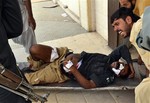 Pakistani's carry an injured police officer from the site of a bombing in Quetta, Pakistan, Thursday, Aug. 8, 2013.