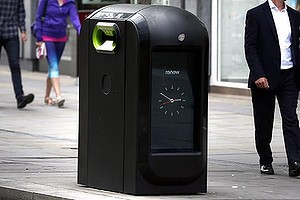 People walk past a trash bin in central London, Monday, Aug. 12, 2013. Officials say that an advertising firm must immediately stop using its network of high-tech trash cans, like this one, to track people walking through London's financial district.The City of London Corporation says it has demanded Renew pull the plug on the program, which measures the Wi-Fi signals emitted by smartphones to follow commuters as they pass the garbage cans. The City of London Corporation is responsible for the city's historic 