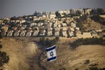 An Israeli flag is seen in front of the West Bank Jewish settlement of Maaleh Adumim, on the outskirts of Jerusalem, Monday, Sept. 7, 2009.