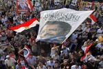 Supporters of Egypt's ousted President Mohammed Morsi wave a banner with his picture and an Arabic slogan that reads, "No god but Allah, and Mohammed is the prophet," during a protest in Nahda Square, where protesters have installed their camp near Cairo University in Giza, in southwestern of Cairo, Egypt, Tuesday, Aug. 13, 2013. Egypt's interim president swore in 20 new provincial governors on Tuesday, a move that reinforces the new leadership's authority and removes all Muslim Brotherhood members previously installed in the posts by Mohammed Morsi before his ouster as president.