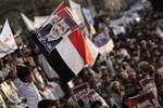 A boy holds a poster of Egypt's ousted President Mohammed Morsi pasted on a Yemeni flag during a rally supporting Morsi in Sanaa, Yemen, Thursday, Aug. 15, 2013. Arabic writing reads, "We are with the legitimacy." Egyptian authorities on Thursday authorized police to use deadly force to protect themselves and key state institutions from attacks, after presumed supporters of the deposed Islamist president torched two local government buildings near the capital in the latest of a series of apparent reprisals to follow a bloody crackdown on their protest camps.