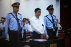 
Bo Xilai (M.) wird von zwei Polizisten im Gerichtssaal vorgeführt
