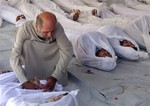 In this citizen journalism image provided by the Media Office Of Douma City, which has been authenticated based on its contents and other AP reporting, a Syrian man mourns over a dead body after an alleged poisonous gas attack fired by regime forces, according to activists, in Douma town, Damascus, Syria, Wednesday, Aug. 21, 2013.