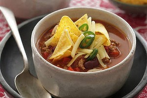 Chilli bean soup with corn chips. Jill Dupleix recipes for Epicure. 
Photographed by Marina Oliphant. Food preparation and styling by Caroline Velik, bowl and fabric from Turner & Lane, MUST CREDIT.