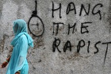 
„Hängt den Vergewaltiger“: Eine Inderin läuft an einem Graffitti an einer Wand in Neu Delhi vorbei. Immer wieder erschüttern Fälle von sexueller Gewalt das Land
