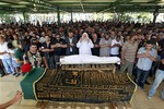 Lebanese mourners and gunmen pray during a funeral for two men killed in a car bomb attack in the northern city of Tripoli, Lebanon, Saturday, Aug. 24, 2013.