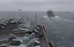 The aircraft carrier USS Harry S. Truman maneuvers alongside the dry cargo/ammunition ship USNS Alan Shepard during a replenishment-at-sea in the Gulf of Oman, 28 August, 2013.