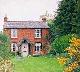 a brick country cottage with a large front garden