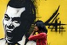 A woman walks past graffiti of former president Mohamed Nasheed in Male.