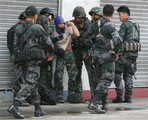 Soldiers check a comrade who was hit by a sniper following a clash between Philippine navy patrol and suspected Moro Islamic Liberation Front rebels aboard several boats off Zamboanga city in southern Philippines Monday, Sept. 9, 2013.