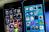 The home screen of an Apple Inc. iPhone 5 operating iOS 6, left, and an iPhone 5C operating iOS 7 is displayed in San Francisco, California, U.S., on Wednesday, Sept. 18, 2013. Buying memory to store more photos, videos and applications on a smartphone costs most consumers about $50. For Apple Inc. customers, it costs four times more than that. Photographer: David Paul Morris/Bloomberg