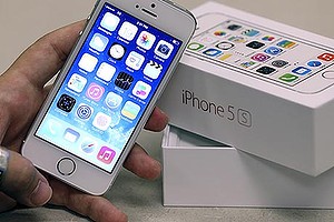 An employee holds the new Apple iPhone 5S at a Verizon store in Orem, Utah September 19, 2013. The iPhone 5C, which comes in blue, green, pink, yellow and white, starts in the U.S. at $99 with a contract and the pricier 