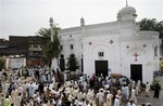 People gather at the site of suicide attack on a church in Peshawar, Pakistan, Sunday, Sept. 22, 2013.