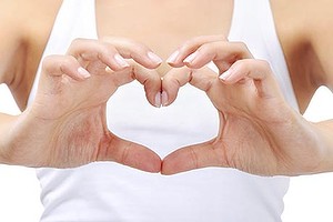 Young woman doing a heart shape