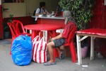 MAN  SITTING IN A  CANTEEN IN N. 