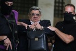 Leader of the extreme far-right Golden Dawn party Nikos Michaloliakos, center, is escorted by anti-terror police as he exits Greek Police headquarters, in Athens, Saturday, Sept. 28, 2013.