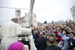 In this picture provided Saturday, Oct. 5, 2013 by the Vatican newspaper L'Osservatore Romano, Pope Francis greets faithful as he arrives in front of St. Francis' Basilica in Assisi, Italy, Friday, Oct. 4, 2013.