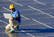 Image of a man sitting on an array of solar panels