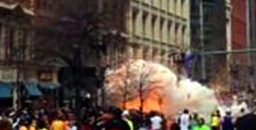 In this image from video provided by WBZ-TV, spectators and participants scramble away from what authorities described as two explosions at the finish line of the Boston Marathon.