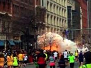  In this image from video provided by WBZ-TV, spectators and participants scramble away from what authorities described as two explosions at the finish line of the Boston Marathon. 