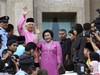 Malaysian new Prime Minister Najib Razak, left in pink, waves with his wife Rosmah Mansor at prime minister's office in Putrajaya, outside Kuala Lumpur, Malaysia, Friday, April 3, 2009.